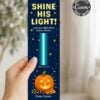 A hand holds a bookmark with a pumpkin, stars, and the text “SHINE HIS LIGHT!” plus a Bible verse; it reads “From Calvin” at the bottom.
