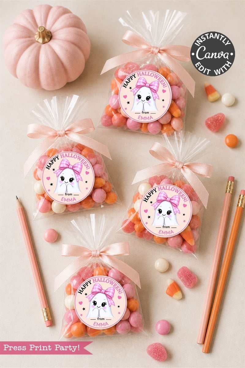 Six Pink Coquette Halloween Ghost Round Labels, four clear bags of candy featuring a cat and “Happy Halloween from Emma,” two orange pencils, a pink pumpkin, and heart and gumdrop candies on a light surface.