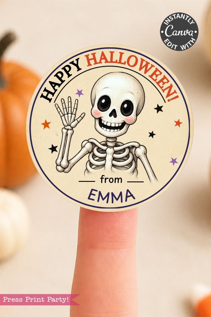 A Halloween sticker on a fingertip shows a waving cartoon skeleton, colorful stars, and the text “Happy Halloween! from Emma.” Pumpkins are blurred in the background.