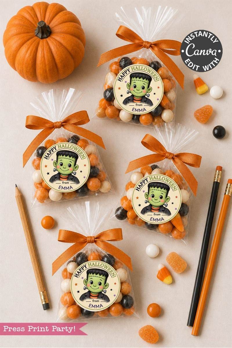 Four Halloween treat bags featuring green cartoon monster labels and orange ribbons, filled with candy corn, pumpkins, a pencil, and a pen, are arranged on a light surface. Pink Coquette Ghost Treat Bag Halloween Stickers add a playful touch to the festive scene, while assorted candies are scattered around for extra charm.