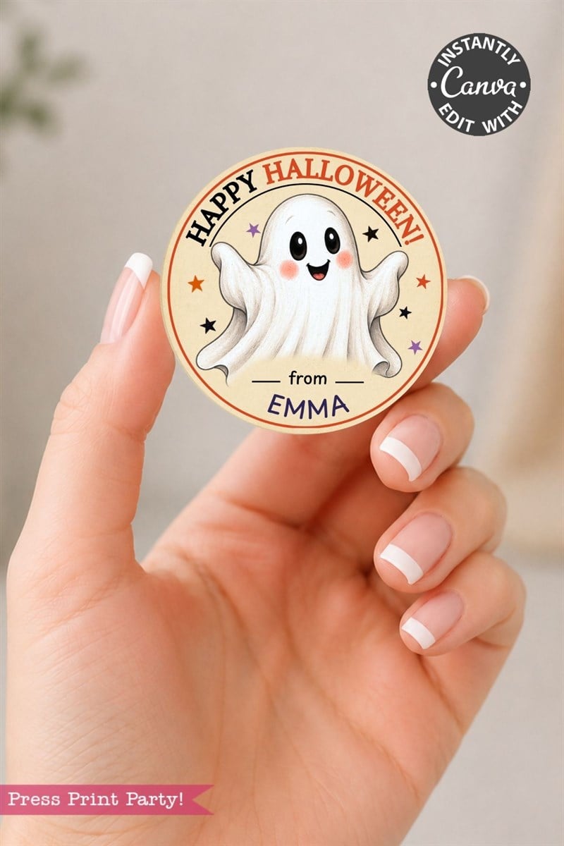 A hand holds a round Pink Coquette Ghost Treat Bag Halloween Sticker, featuring a cute smiling ghost, stars, and the text “from Emma.” The sticker showcases a pink coquette Halloween style and includes an editable Canva label in the corner.