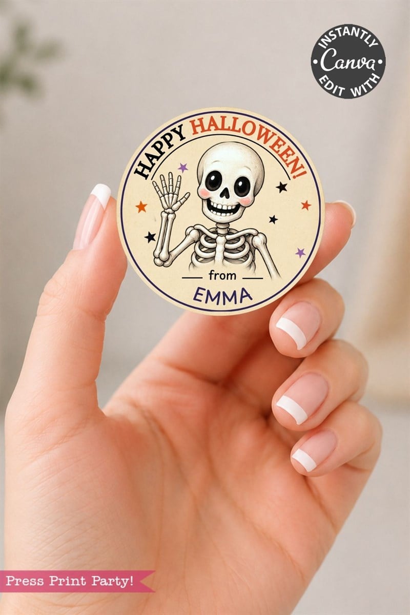 A hand holds a round Pink Coquette Ghost Treat Bag Halloween Sticker featuring a waving skeleton with the message “Happy Halloween from Emma” and colorful stars. The sticker is editable with Canva.
