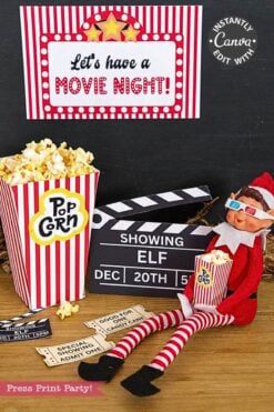 A toy elf wearing 3D glasses sits next to popcorn, a clapperboard, and printable movie tickets from the Elf Arrival Printable Bundle, Christmas Elf Kit under a “Let’s have a MOVIE NIGHT!” sign for this elf arrival scene.