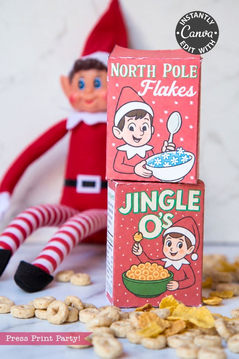 A toy elf sits behind two small, stacked cereal boxes labeled North Pole Flakes and Jingle O’s, surrounded by loose cereal pieces as part of an Elf Arrival Printable Bundle, Christmas Elf Kit.