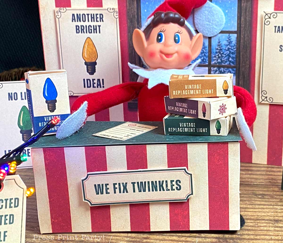 An elf figurine sits behind a βWe Fix Twinklesβ booth with miniature vintage replacement light bulb boxes.