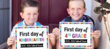 Two smiling boys sit on a doorstep holding colorful first day of school signs. The younger boy’s says "First day of Kindergarten, 2025-2026," while the older boy’s sign marks his "First day of 4th Grade." Perfect for your own first day of school printable memories!.