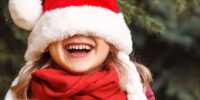 50 actually funny christmas jokes for kids - laughing girl with santa hat - Press Print Party!