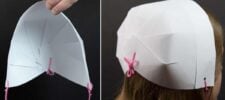 Person wearing a white paper pilgrim bonnet secured with pink yarn. The image showcases a side view of the bonnet on the head, along with a close-up of the internal paper folds, highlighting this charming DIY project.